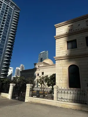a building with a fence in front of some buildings at Spacious 1 Bedroom Apartment-Opal Tower Dubai Marina in Dubai