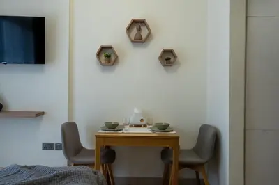 a small table with two chairs in a room at Roomook Cozy studio in Dubai
