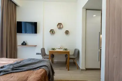 a bedroom with a desk and a table with chairs at Roomook Cozy studio in Dubai