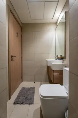 a bathroom with a toilet and a sink and a mirror at Roomook Cozy studio in Dubai