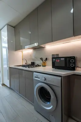 a kitchen with a washing machine and a microwave at Roomook Cozy studio in Dubai