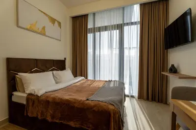 a hotel room with a bed and a large window at Roomook Cozy studio in Dubai