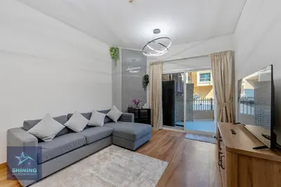 a living room with a couch and a television at Modern 1BR Apartment in JVC Pool Gym Near Circle Mall in Dubai