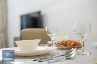 a table with two wine glasses and a plate of food at Modern 1BR Apartment in JVC Pool Gym Near Circle Mall in Dubai