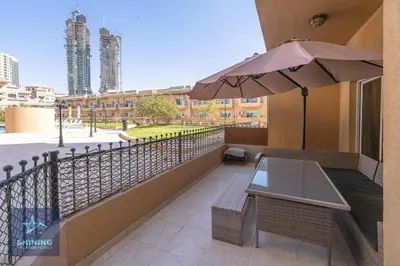 a balcony with a table and an umbrella at Modern 1BR Apartment in JVC Pool Gym Near Circle Mall in Dubai