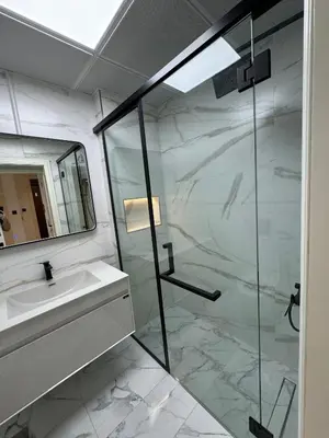 a bathroom with a glass shower and a sink at Burj Khalifa & Canal View Apartment in Dubai