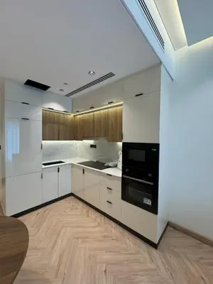 a kitchen with white cabinets and a black oven at Burj Khalifa & Canal View Apartment in Dubai