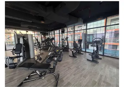 a gym with treadmills and exercise equipment in a building at Magra CHILL SPOT HOSTEL in Sabkhah