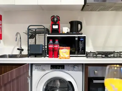 a kitchen with a washing machine and a microwave at Charming & Cozy 1BR Burj Khalifa Skyline View in Dubai