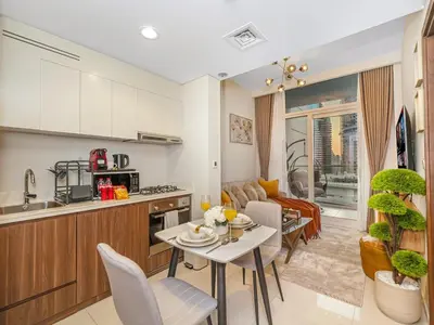 a kitchen and living room with a table and chairs at Charming & Cozy 1BR Burj Khalifa Skyline View in Dubai