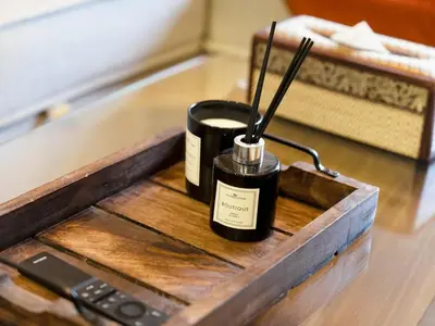 a wooden table with two candles and a remote control at Charming & Cozy 1BR Burj Khalifa Skyline View in Dubai