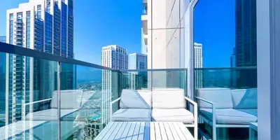 a balcony with white chairs and a view of a city at Luxury in Dubai 2 bedroom apartment with balcony in Dubai