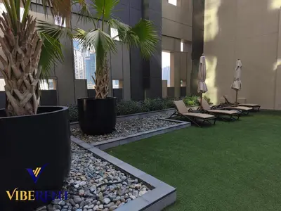 a lobby with chairs and palm trees in a building at Business Bay Retreat,Views & Vibes,10 min to Burj in Dubai