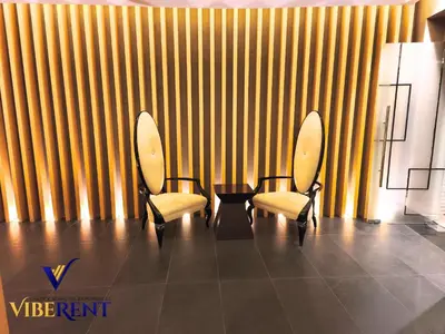 two chairs and a table in a room with yellow stripes at Business Bay Retreat,Views & Vibes,10 min to Burj in Dubai