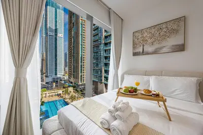 a bedroom with a bed with a view of the city at Livin' Holidays - 1 BR - Paradise getaway Dubai Marina in Dubai