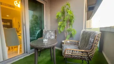 two chairs and a table on a porch at Damac Maison Downtown Dubai Luxury 1BR Walk to Dubai Mall in Dubai
