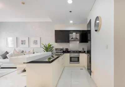 a kitchen and living room with white walls at Damac Maison Downtown Dubai Luxury 1BR Walk to Dubai Mall in Dubai