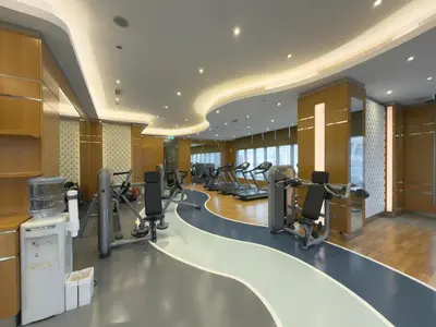 a gym with a row of treadmills and ellipticals at Damac Maison Downtown Dubai Luxury 1BR Walk to Dubai Mall in Dubai