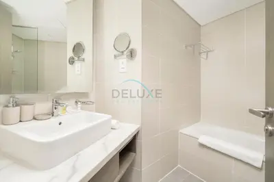 a white bathroom with a sink and a tub at Picture-Perfect Canal and City Views, Minutes from Waterfront Transport, Easy Access to Downtown Delights, Prive by Damac B, Business Bay by Deluxe Holiday Homes in Dubai