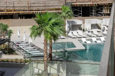 a pool with chairs and a palm tree in a building at Modern Studio in Business Bay in Dubai