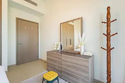 a bathroom with a wooden dresser and a mirror at Luxury 1BR Downtown, Pool, Gym, Opera District in Dubai