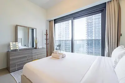 a bedroom with a large window and a white bed at Luxury 1BR Downtown, Pool, Gym, Opera District in Dubai