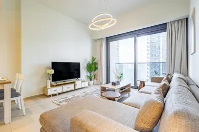 a living room with a couch and a large window at Luxury 1BR Downtown, Pool, Gym, Opera District in Dubai