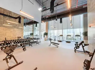 a gym with several rows of treadmills and machines at the space in Dubai