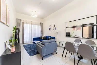 a living room with a blue couch and a table at HAVN - 1 bedroom in The Wings, Arjan in Dubai
