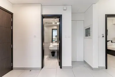 a bathroom with white walls and a bathroom with a sink at HAVN - 1 bedroom in The Wings, Arjan in Dubai