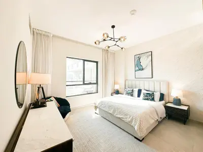 a white bedroom with a bed and a window at Stunning 1 Bed Large Luxury Apt with Pool View Al Barari by Luxaura in Dubai