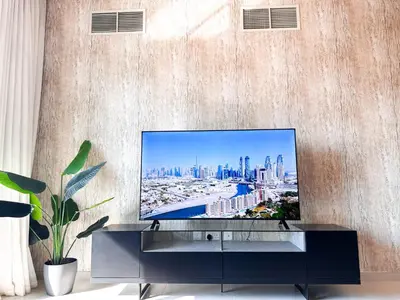 a living room with a flat screen tv on a wall at Stunning 1 Bed Large Luxury Apt with Pool View Al Barari by Luxaura in Dubai