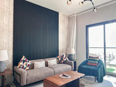 a living room with a couch and a chair at Stunning 1 Bed Large Luxury Apt with Pool View Al Barari by Luxaura in Dubai