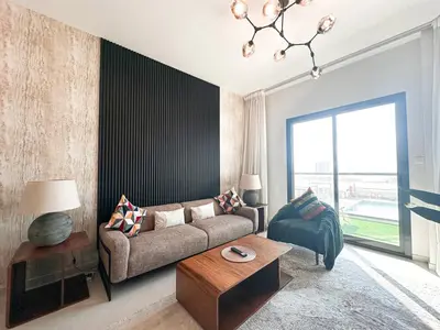 a living room with a couch and a table at Stunning 1 Bed Large Luxury Apt with Pool View Al Barari by Luxaura in Dubai