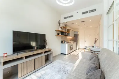 a living room with a large flat screen tv at HAVN - Cozy 1 bedroom in Golfville in Dubai