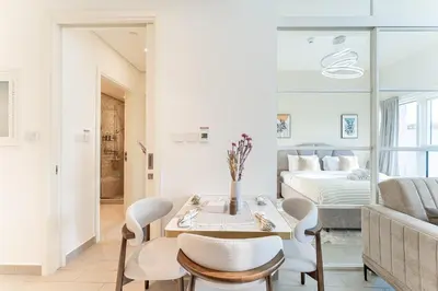 a living room with a bed and a table and chairs at HAVN - Cozy 1 bedroom in Golfville in Dubai