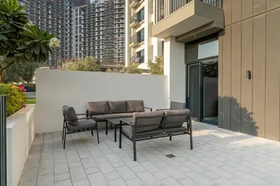 a patio with a table and two chairs and a building at HAVN - Cozy 1 bedroom in Golfville in Dubai