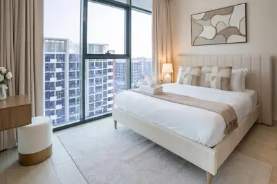 a bedroom with a large white bed and large windows at Airstay - Bright Top-Floor 1BR - Azizi Riviera 8 - Monthly Offer Available! in Dubai