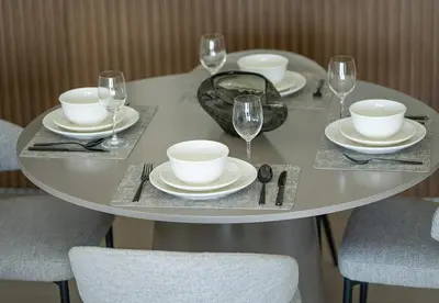a table with plates and wine glasses on it at Modern 1 Bed Apartment in Binghatti Orchid in Dubai