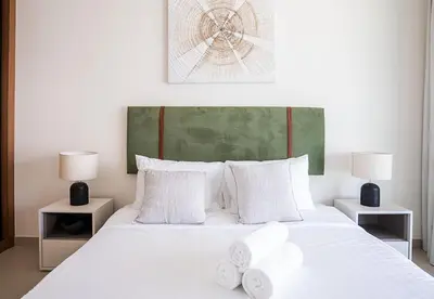 a white bed with two white towels on it at Modern 1 Bed Apartment in Binghatti Orchid in Dubai