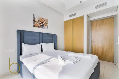 a bedroom with a large bed with a blue headboard at Bookable 1 Bed Aykon City with Amazing Bird eye view in Dubai