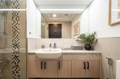 a bathroom with a white sink and a shower at Elegant 3 BR - Stunning Burj Khalifa Views in Dubai
