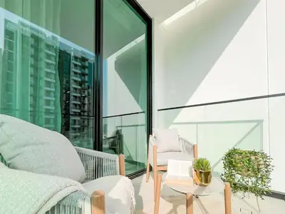 a living room with a chair and a table at Radiant Studio in Binghatti Azure with Pool & Gym in Dubai