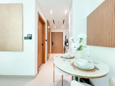 a dining room with a white table and chairs at Radiant Studio in Binghatti Azure with Pool & Gym in Dubai