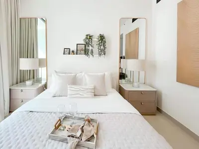 a bedroom with a white bed with a tray on it at Radiant Studio in Binghatti Azure with Pool & Gym in Dubai