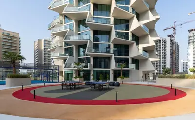 a building with tables in front of it at Airy 1BR Oasis with Plunge Pool in Binghatti Phantom in Dubai