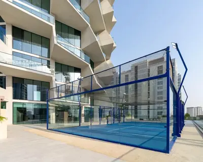 a tennis court in front of a building at Airy 1BR Oasis with Plunge Pool in Binghatti Phantom in Dubai