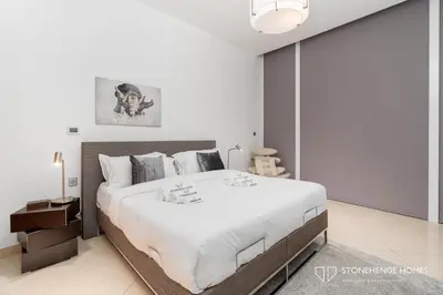 a bedroom with a large bed with white sheets at Sky-High 3BR in Trident Grand Residence in Dubai Marina & JBR with Epic Sea, Palm & Dubai Eye View in Dubai