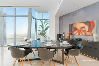 a dining room with a table and a painting at Sky-High 3BR in Trident Grand Residence in Dubai Marina & JBR with Epic Sea, Palm & Dubai Eye View in Dubai