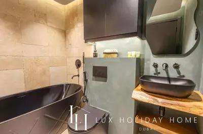 a bathroom with a black sink and a tub at LUX The Contemporary Marina View Suite 7 in Dubai